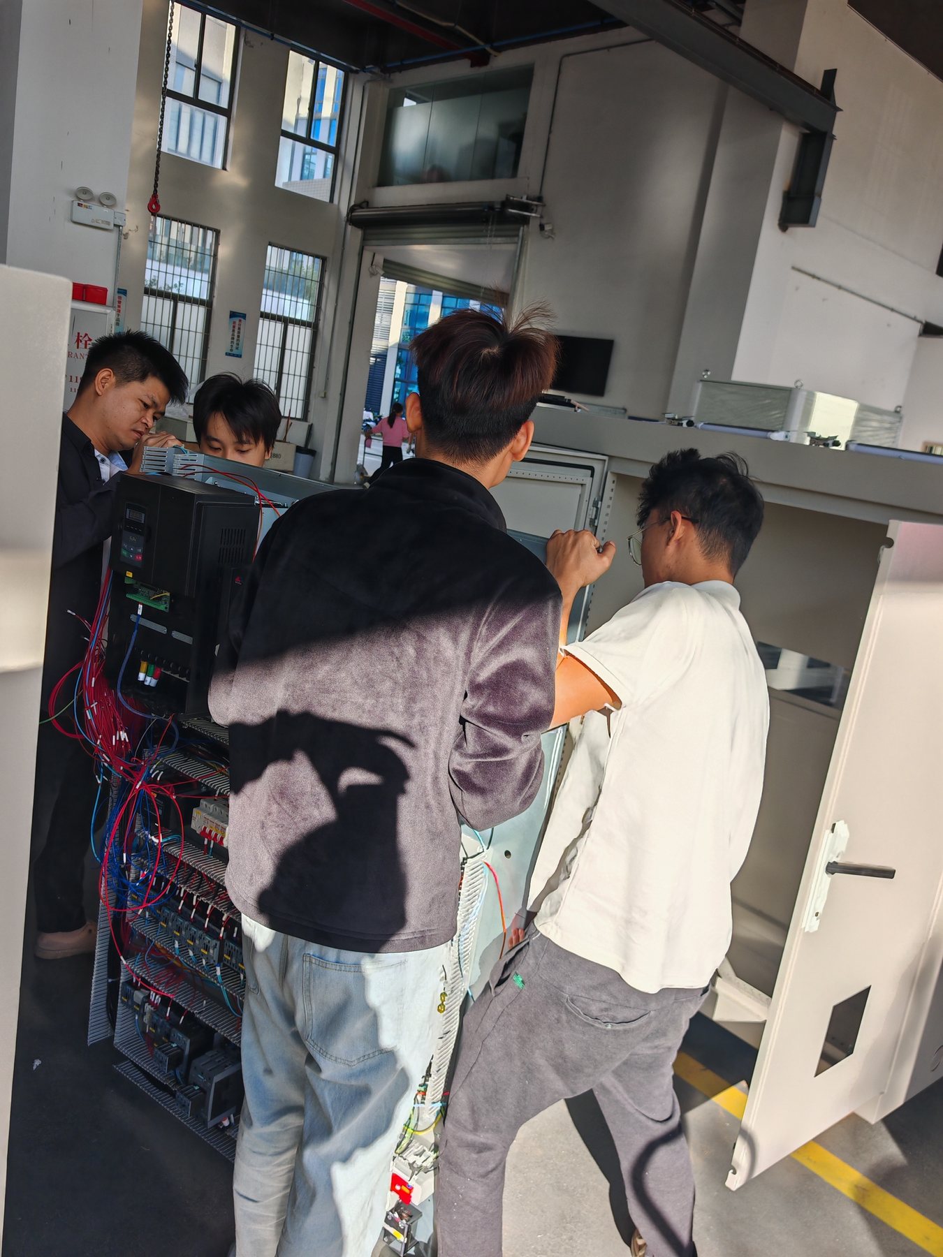 Multiple technicians assembling electrical control cabinets
